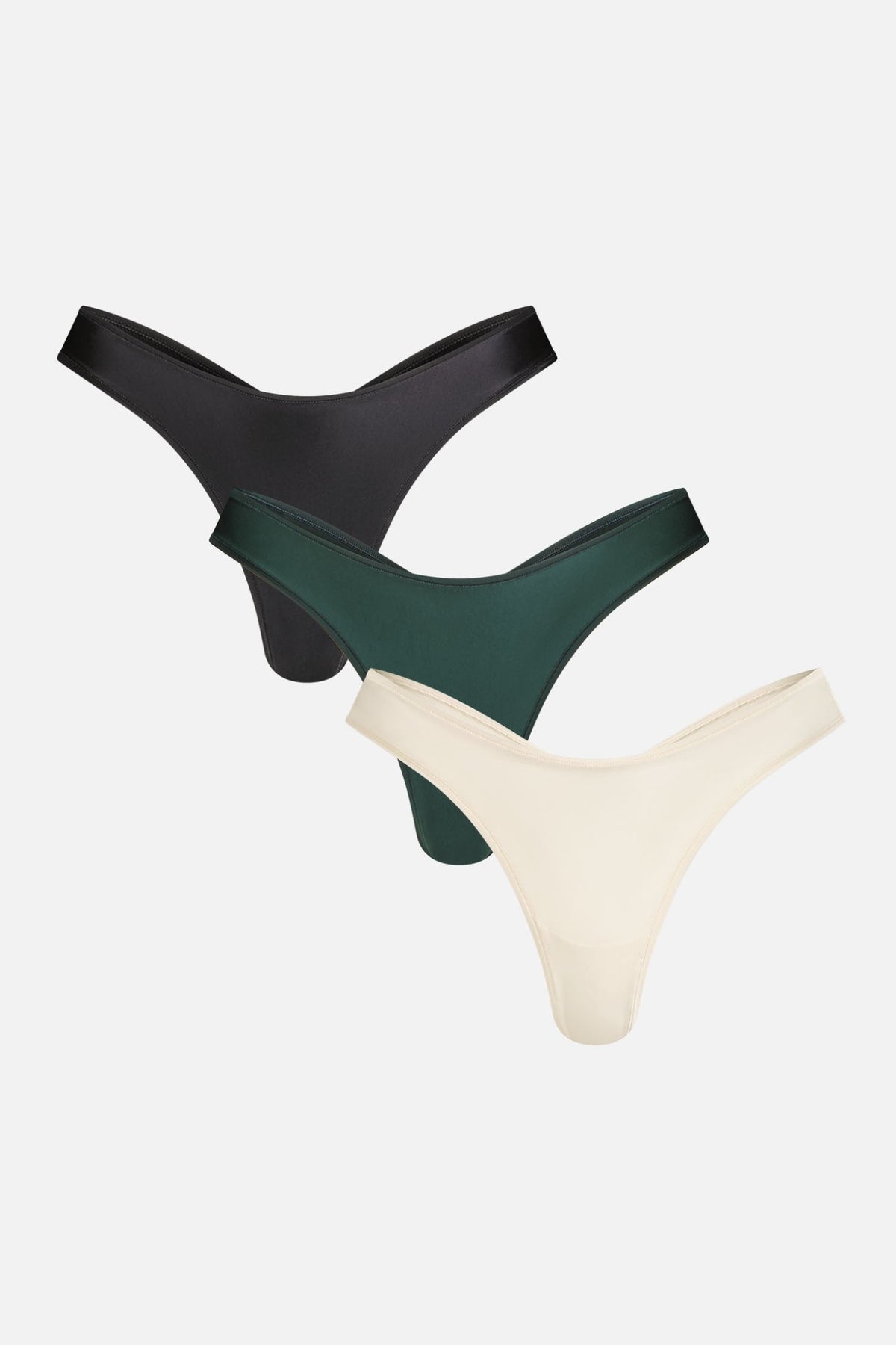 Nocturne Glacé dipped thong 3-pack in Black, Cypress and Cream, flat lay