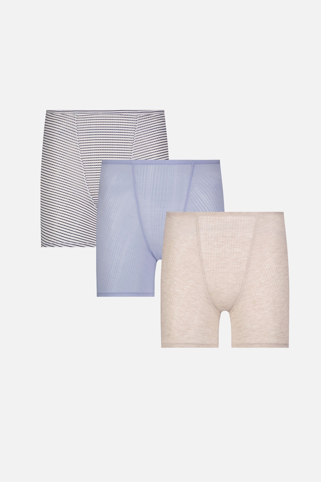 Three pairs of women's boxer briefs arranged in a staggered stack on a light gray background: a pair with thin dark horizontal stripes, a pair in light periwinkle blue, and a pair in light heathered beige.