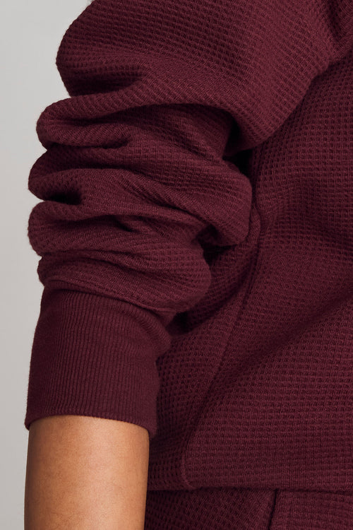 Garnet waffle knit deep-v sweatshirt, detail view of neckline and waffle texture
