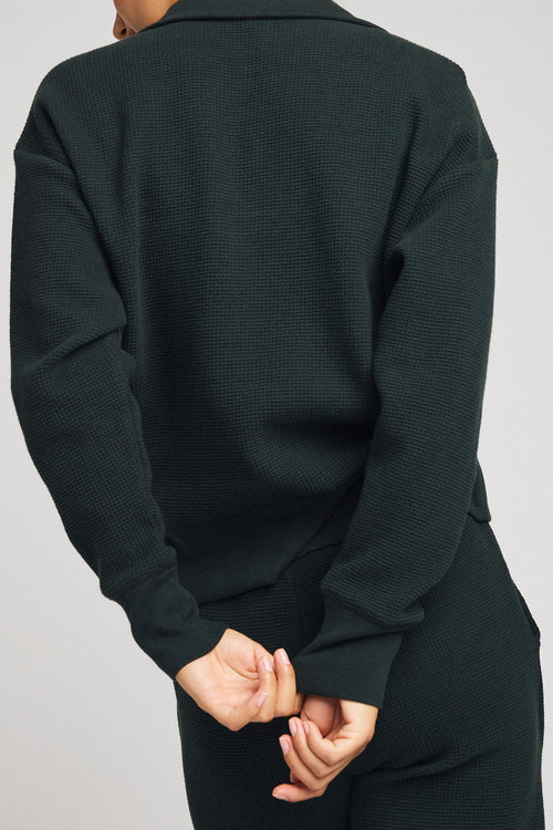 Dark teal waffle-knit pullover back view with ribbed hem and long sleeves