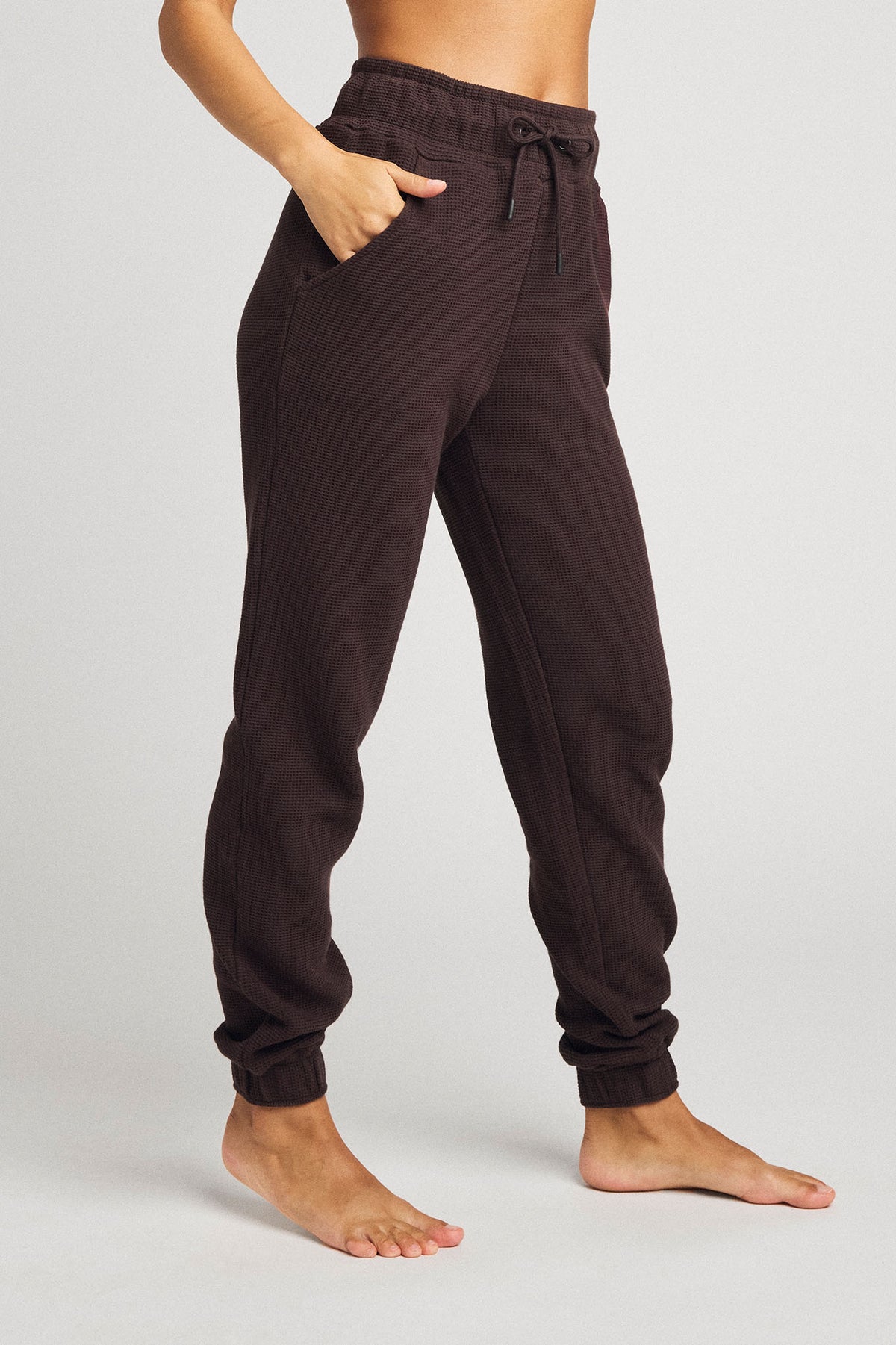 Dark brown waffle-knit jogger pants with drawstring waist and tapered cuffed legs