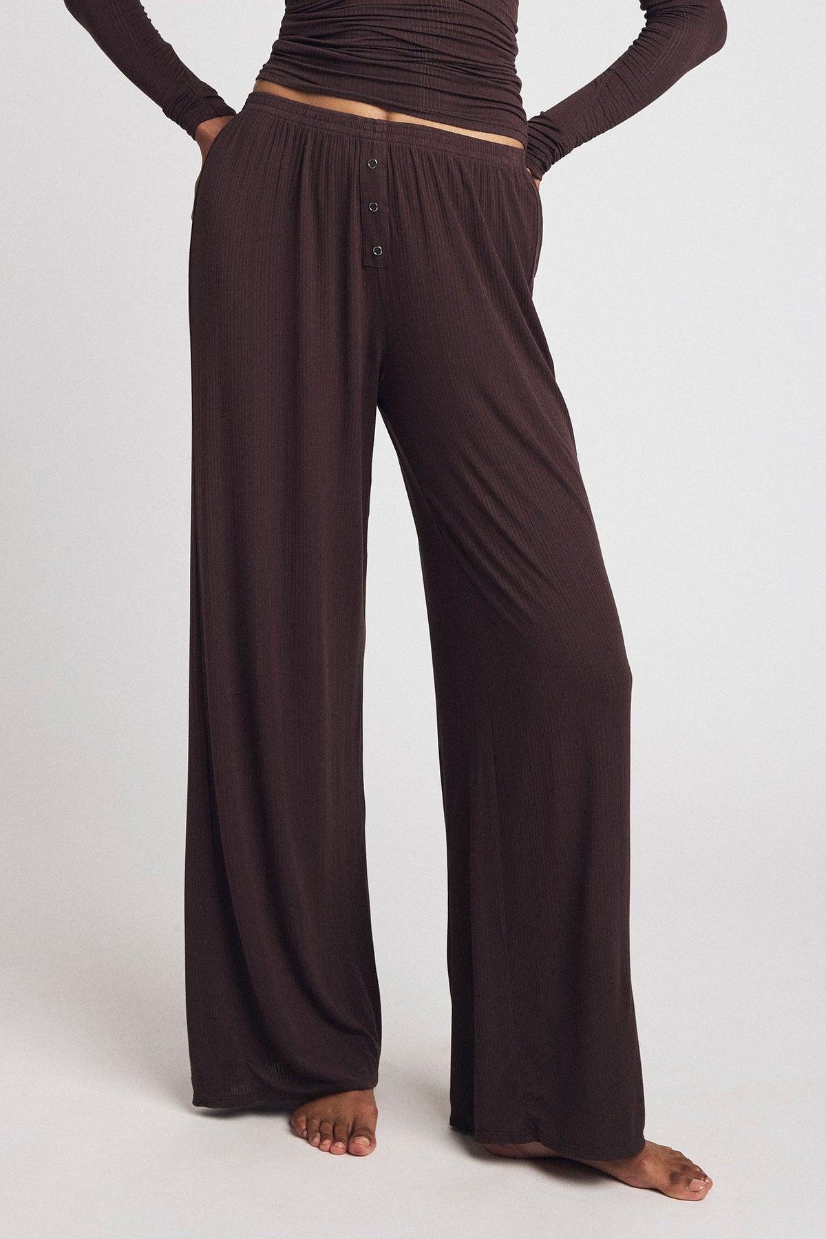 Dark brown wide-leg track pants with elastic waist and contrast tan stripe
