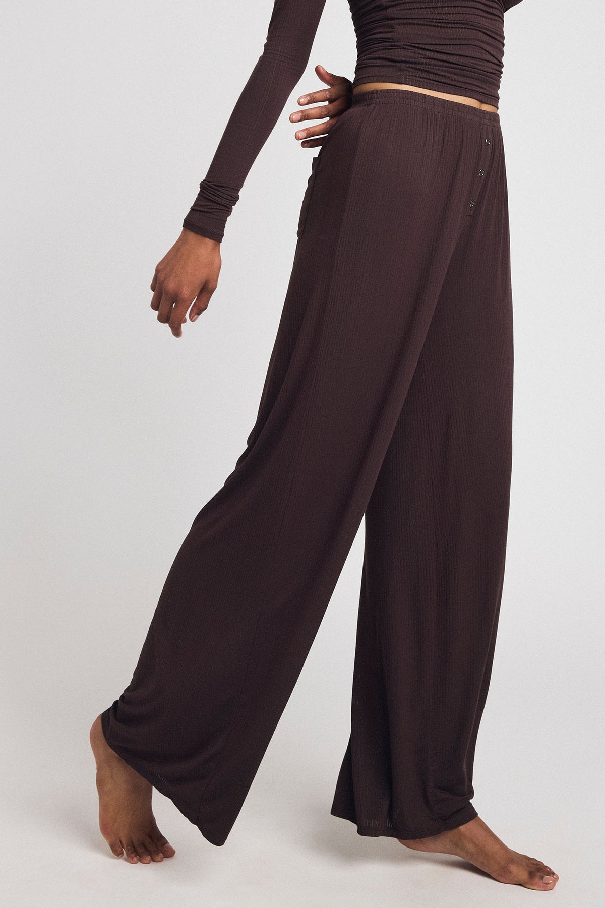 Dark brown wide-leg track pants with elastic waist and tan side stripe detail