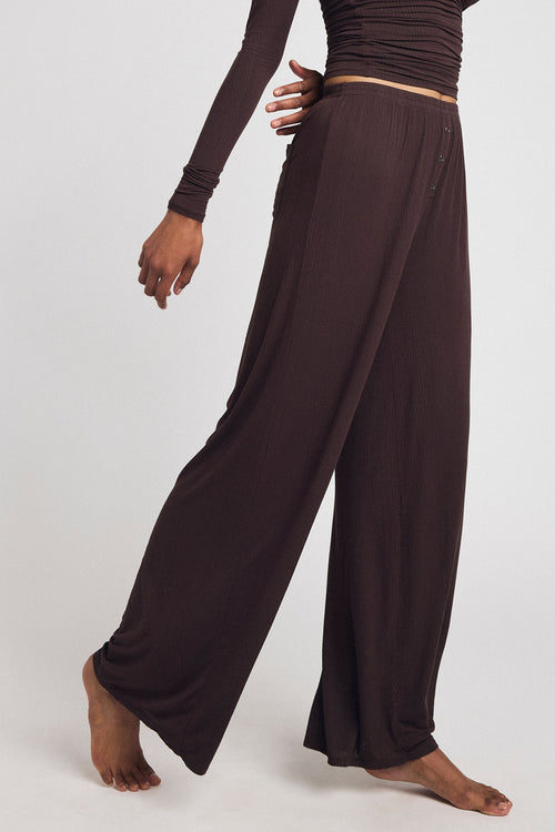 Dark brown wide-leg track pants with elastic waist and tan side stripe detail