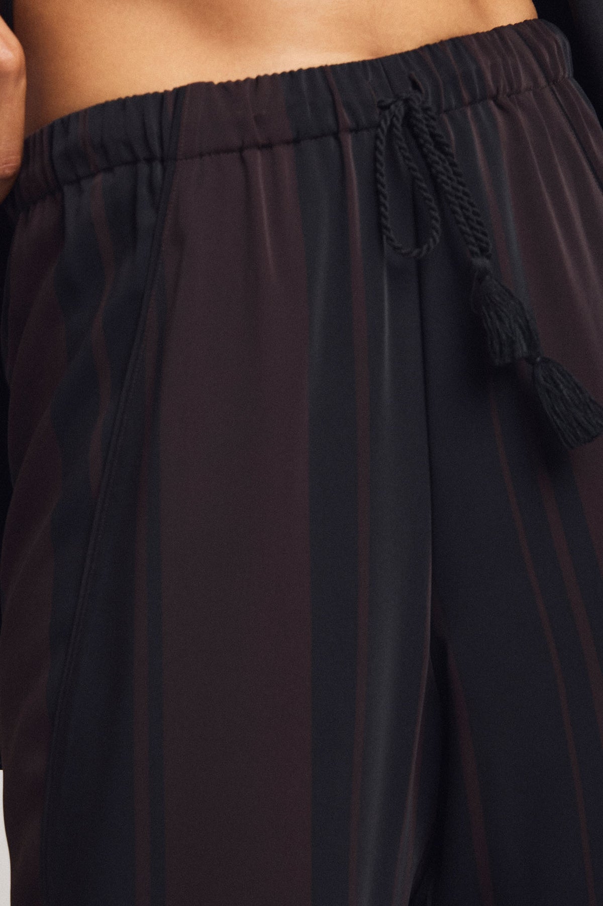 Dark jogger pants close-up of striped fabric and drawstring waist